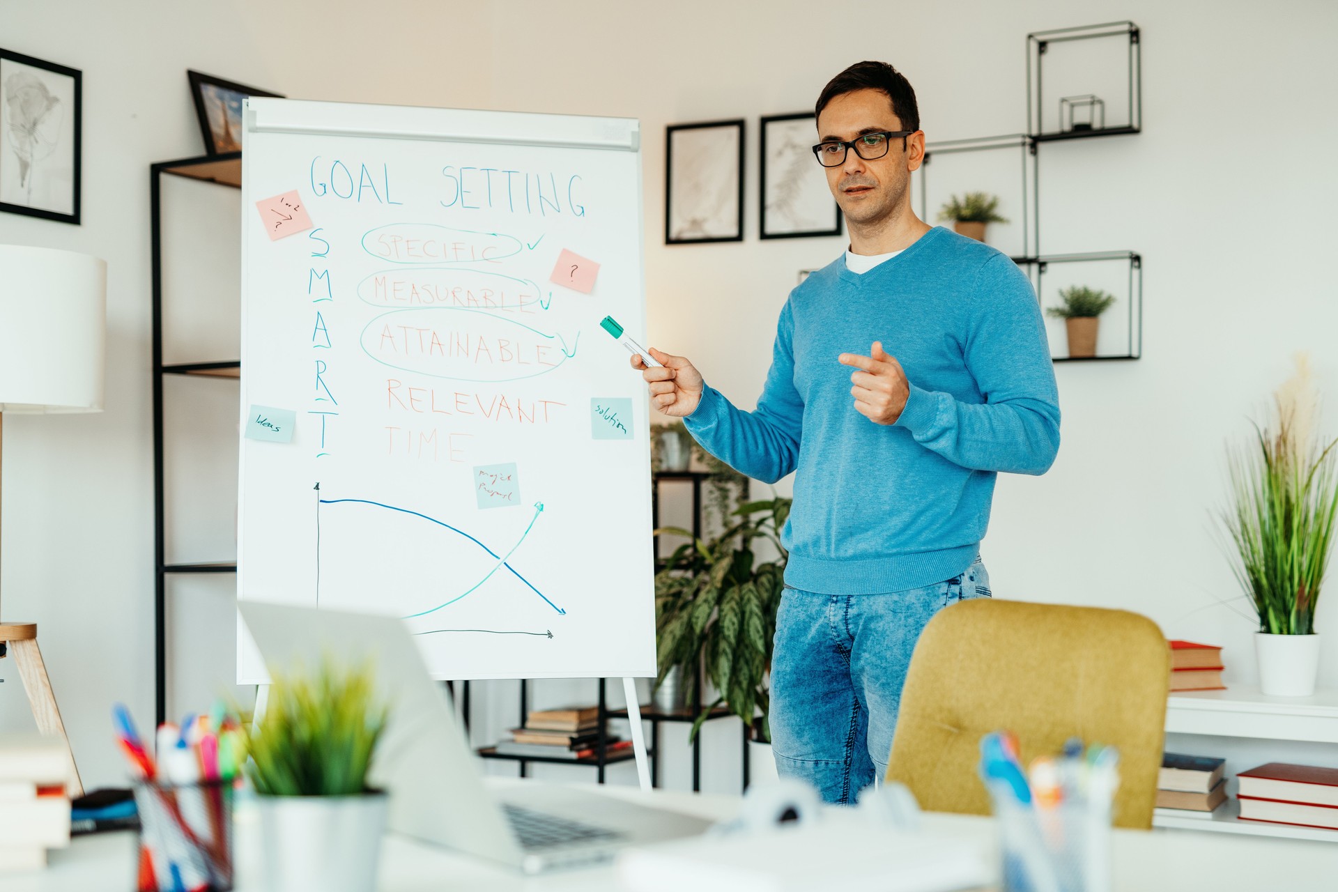 Mature motivator having online lectures, using laptop and whiteboard for students